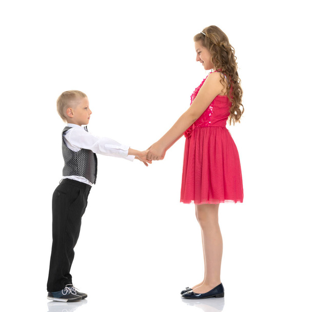Egy fiú és egy lány kezében tartja. A koncepció a barátság, boldog gyermekkor. Elszigetelt fehér background. - Fotó, kép