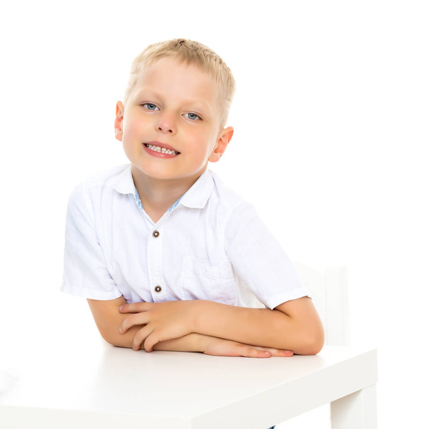 A little boy is sitting at the table. - Φωτογραφία, εικόνα