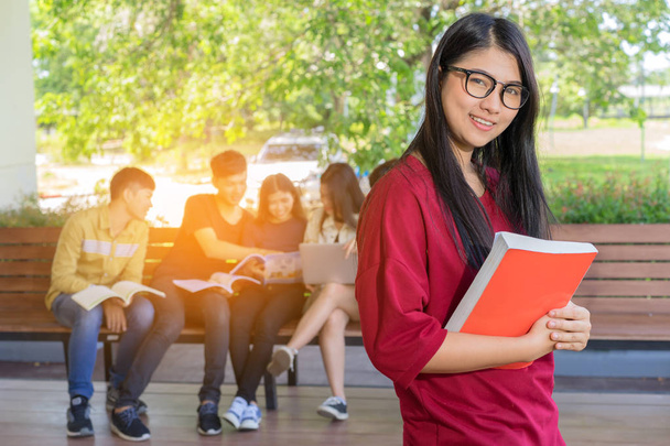 Education first, Beautiful female college student holding her books smiling happily standing in an auditorium people education learning high school program smart teenager concept copy space - Photo, Image