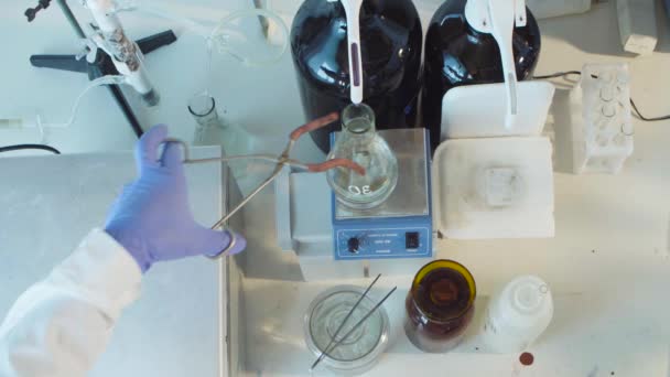 Hands place the flask on the magnetic stirrer - Footage, Video
