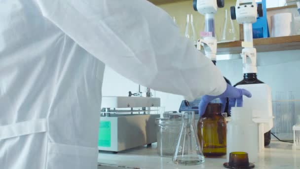 Tiedemiehen kädet, jotka pudottavat reagenssia pulloihin
 - Materiaali, video