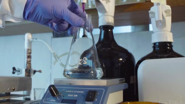 Hände eines Wissenschaftlers titrieren Lösung - Filmmaterial, Video