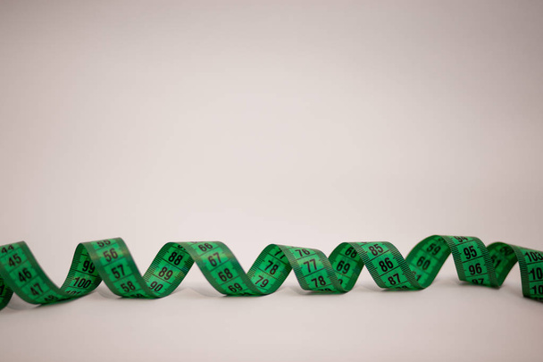 Zöld elszigetelt fehér background mérőszalag. Mérőszalag Tailor, a tervez - Fotó, kép