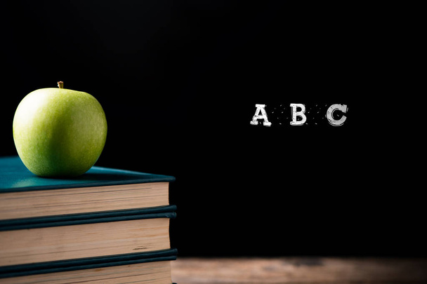 Manzana verde en libros a un centro escolar. Volver a la escuela Concepto
 - Foto, imagen
