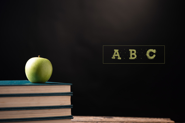Grüner Apfel auf Bücher zu einem Schulzentrum. zurück zum Schulkonzept - Foto, Bild
