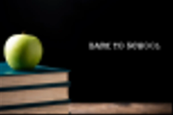 Zielone jabłko na książki do szkoły centrum. Powrót do szkoły koncepcja - Zdjęcie, obraz
