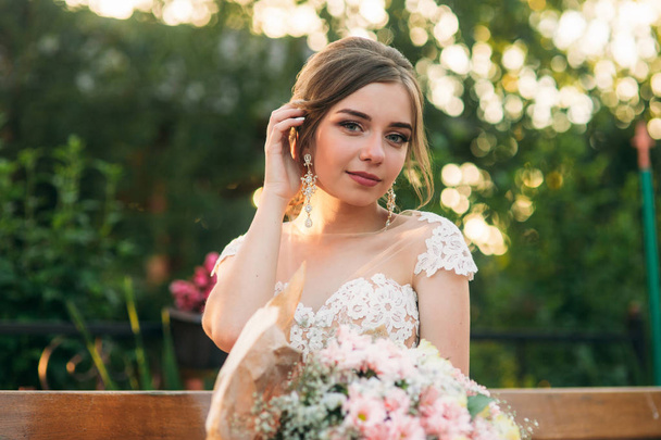 Jeune fille en robe de mariée dans le parc posant pour photographe
 - Photo, image