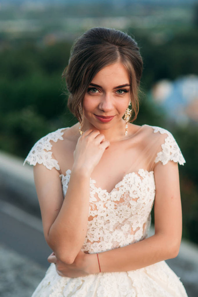 Teenage girl in wedding dress on city. Background town sunset - Foto, immagini