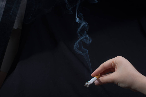 Рука тримає палити цигарку з димом навколо
 - Фото, зображення