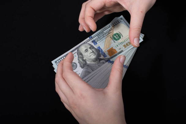 Beyaz arka planda el ele tutuşan Amerikan doları banknotları - Fotoğraf, Görsel