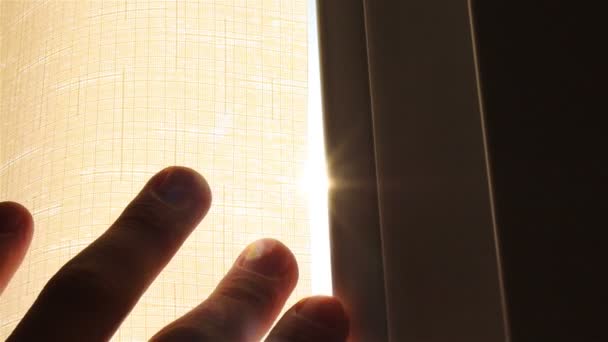 De hand heeft betrekking op het gordijn. De stralen van de zon. Is een landschap buiten het raam. Close-up. Slow Motion - Video