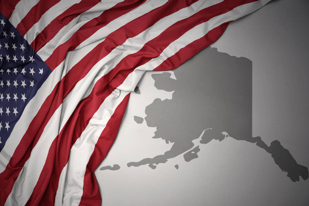 vilkuttaa värikäs kansallinen lippu Amerikan yhdysvaltojen harmaa alaska valtion kartta tausta
. - Valokuva, kuva