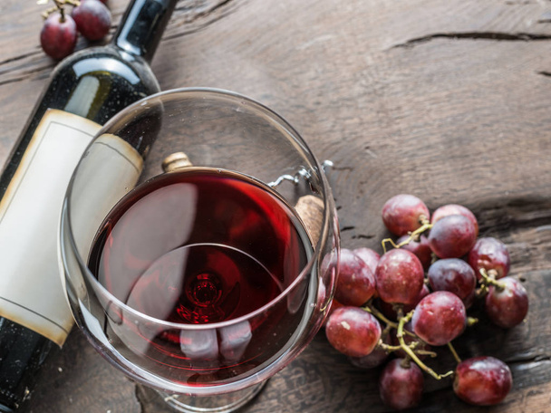 Wine glass, wine bottle and grapes on wooden background. Wine tasting. - Valokuva, kuva