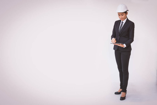 giovane donna d'affari in tuta e casco protettivo sta utilizzando un tablet digitale
 - Foto, immagini