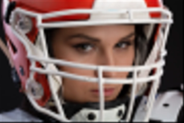 Portret Seksowny atrakcyjny młoda dziewczyna z jasny makijaż w strój sportowy dla rugby z kask na głowę mocno patrząc do przodu stojąc na czarnym tle. równość płci - Zdjęcie, obraz