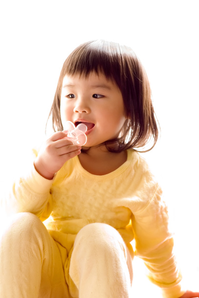 素敵なアジアの赤ちゃんに座るし、おしゃぶりを吸う - 写真・画像