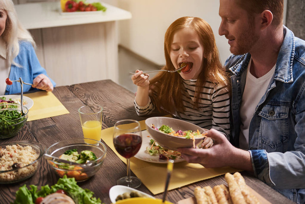Happy father and daughter eating together - Photo, Image