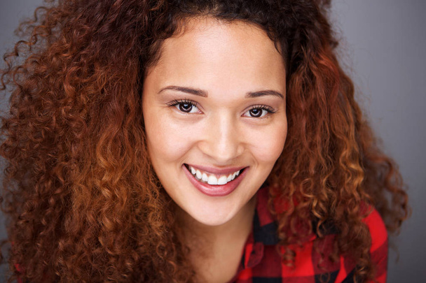 Primer plano retrato de sonriente chica de raza mixta con el pelo rizado
 - Foto, Imagen