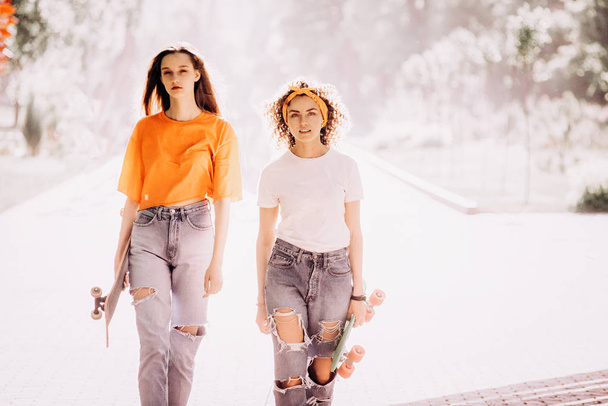 Two beautiful young hippie woman model in summer white hipster clothes posing in the street - Photo, Image