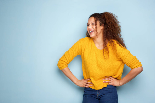 Πορτρέτο του όμορφη νεαρή γυναίκα γελάει με μπλε φόντο - Φωτογραφία, εικόνα