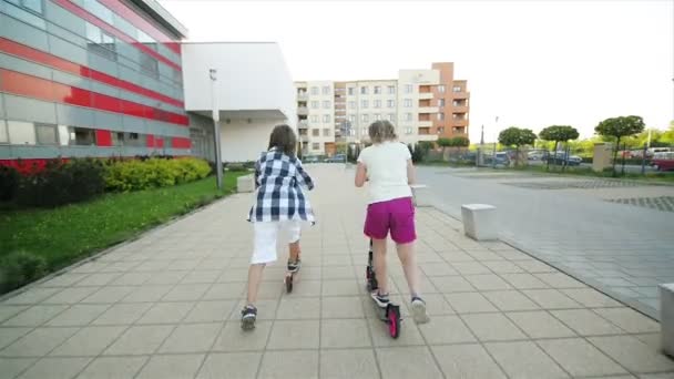 Children Learn To Ride Scooter On Sunny Summer Day. Kids Play Outdoors With Scooters. Active Leisure and Outdoor Sport For Child. - Záběry, video
