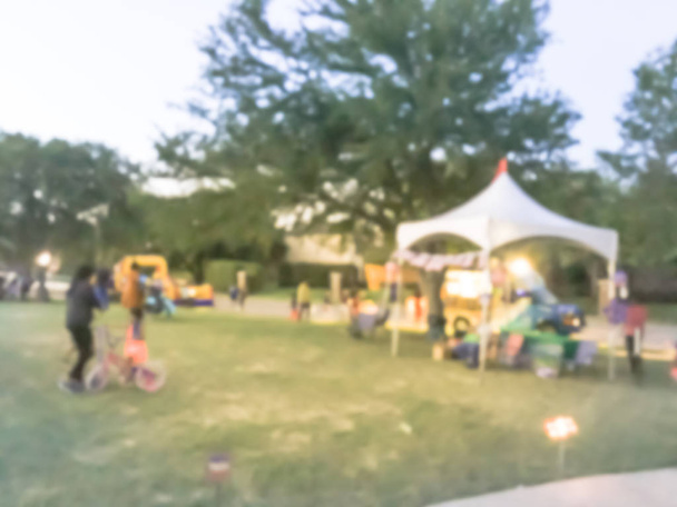 Движение размыло разнообразную группу местных жителей на праздновании 4 июля. Абстрактный фон Четвертое июля празднуют вечером с организаторами стендов, палатки в Ирвинге, штат Техас, США
. - Фото, изображение