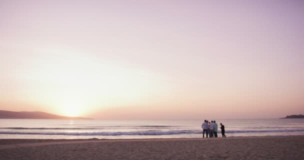 lassú mozgás silhouette csoport fiatal beach party-reggel gyönyörű napfelkelte után - Felvétel, videó