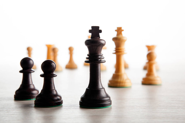 black chess pawns on a chessboard and a black chess king a white background - 写真・画像
