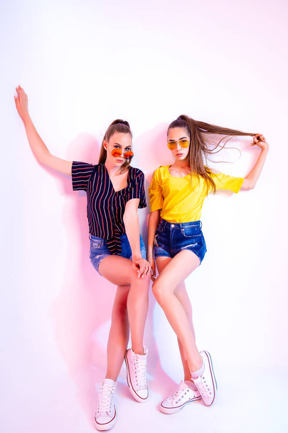 Teenage girls in sunglasses standing in studio - Foto, afbeelding