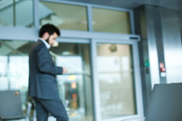 Кавказский бизнесмен едет в офис в сером костюме
. - Фото, изображение