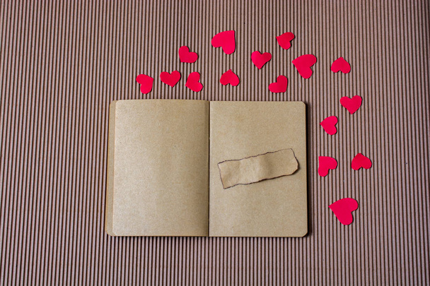 Papír szívek körül notebook szakadt papír rajta - Fotó, kép