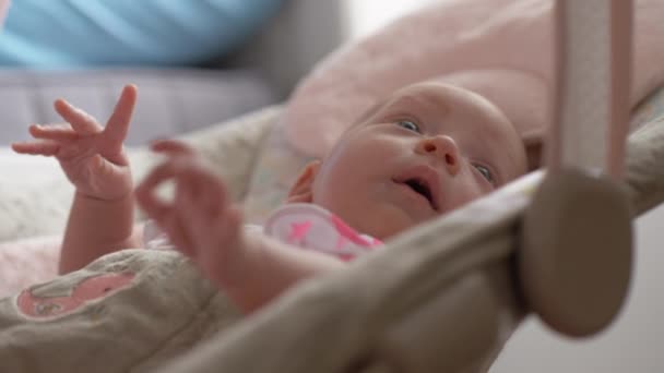 Calm baby girl in bouncy seat at home - Filmmaterial, Video