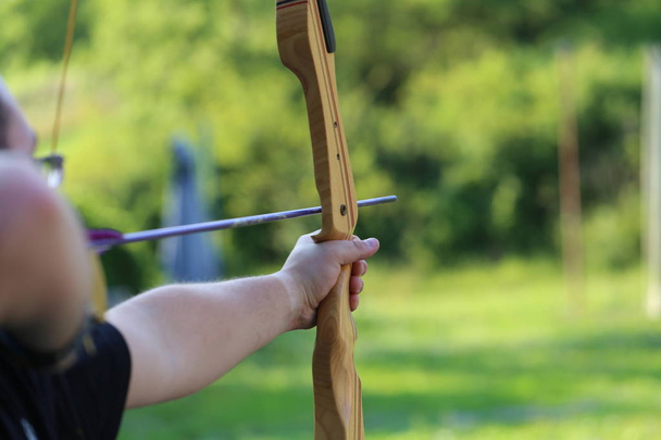 Archery / Shooter prepares for the shot and aims to shoot the bow in the target / Fragments - 写真・画像