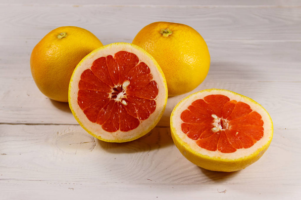 Reife frische Grapefruits auf weißem Holztisch - Foto, Bild