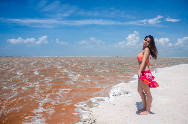Las Coloradas のピンクの海の近くの美しい若い女性 - 写真・画像