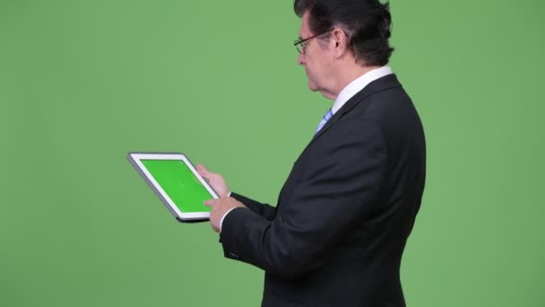 Senior handsome businessman using digital tablet - Imágenes, Vídeo
