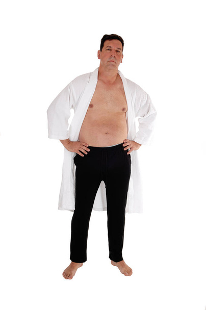 Komea keski-ikäinen mies seisoo ilman paitaa valkoisissa
 - Valokuva, kuva