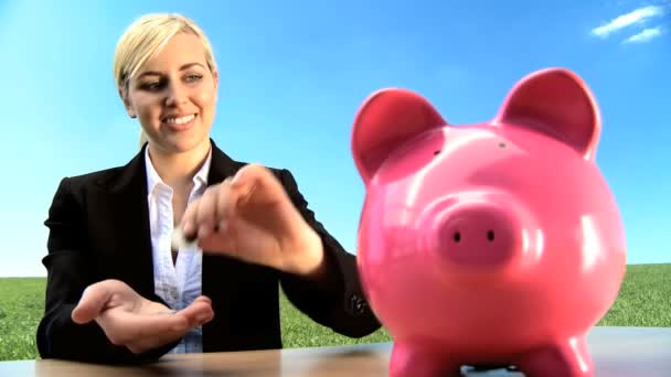 Businesswoman using money pig for green investment in an environmental future - Footage, Video
