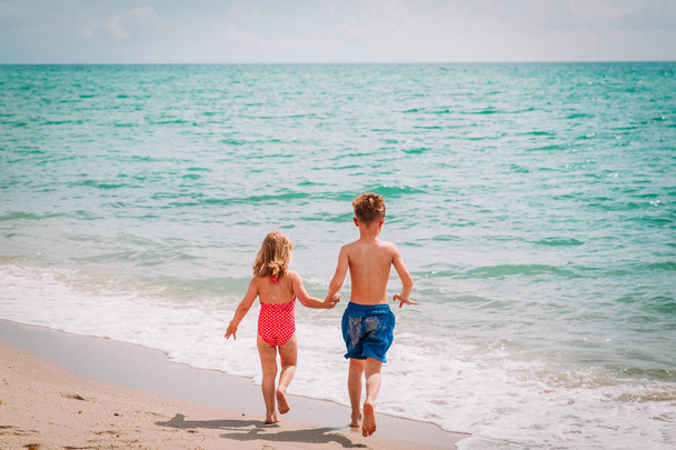 маленький мальчик и девочка бегают играть на пляже
 - Фото, изображение
