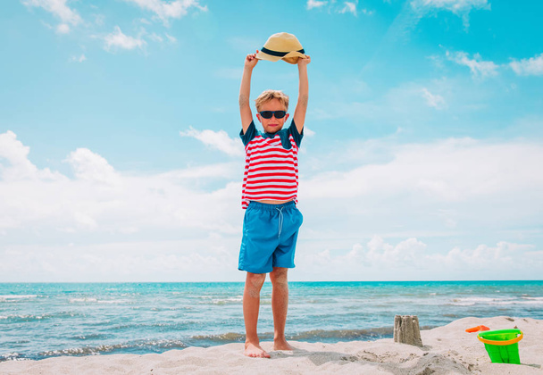 счастливый мальчик поднимает руки и наслаждается пляжем
 - Фото, изображение