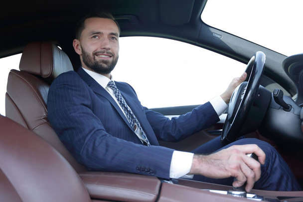 View from the side confident businessman sits at the wheel of a car - Foto, Imagen