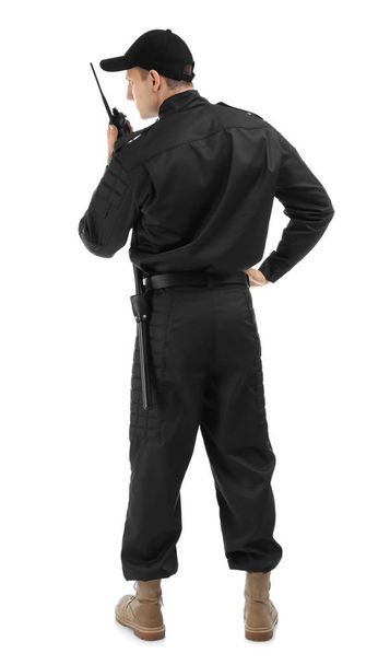 Male security guard using portable radio transmitter on white background - Fotó, kép