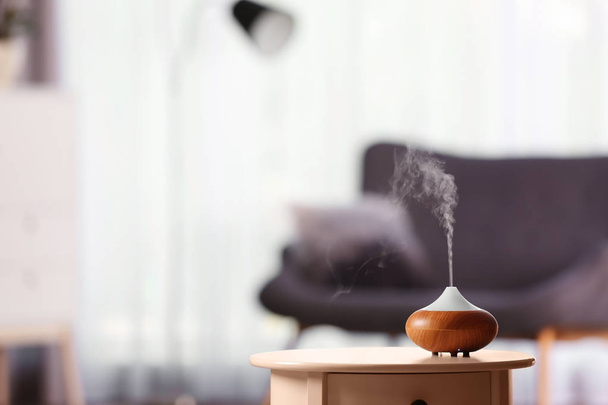 Aroma oil diffuser on table against blurred background. Air freshener - Zdjęcie, obraz