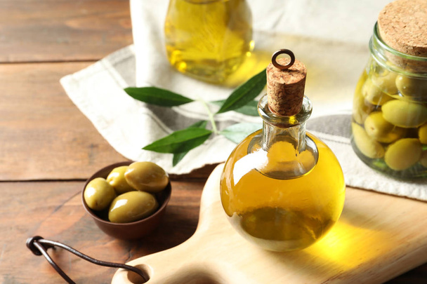 Composition with fresh olive oil on table - Фото, изображение
