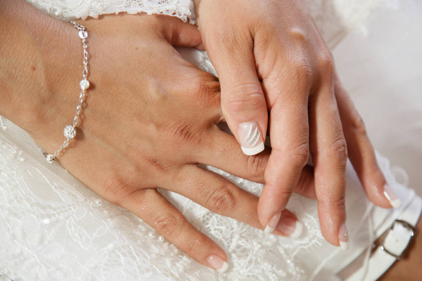 Female hands on the wedding dress the bride morning preparing for the wedding white nails manicures - Photo, Image