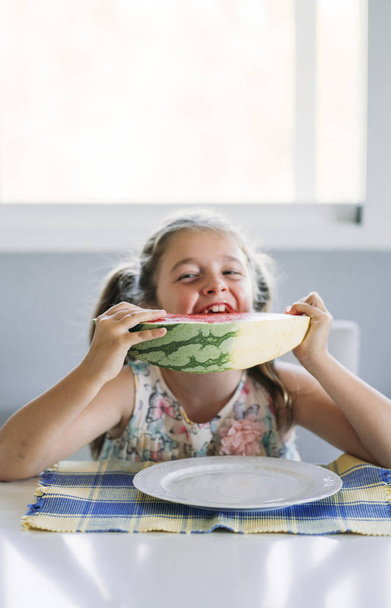 Küçük kız masada karpuz yeme - Fotoğraf, Görsel