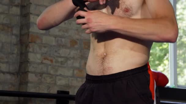 Schuss eines männlichen MMA-Kämpfers, der sich vor dem Kampf die Knöchel umschnallt - Filmmaterial, Video