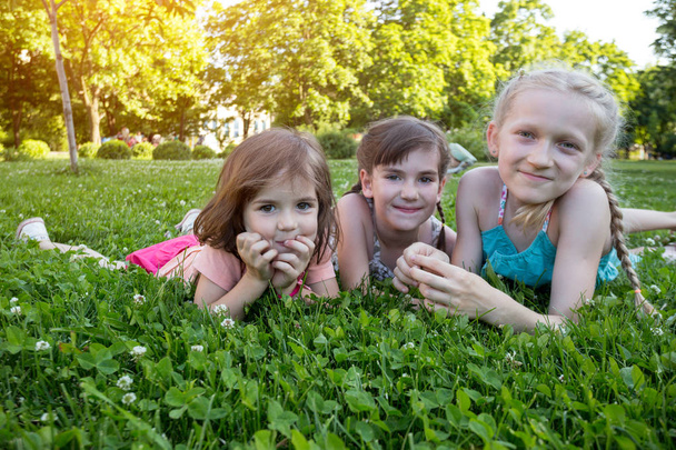 niñas sonrientes novias en la hierba verde. vacaciones infantiles
 - Foto, imagen