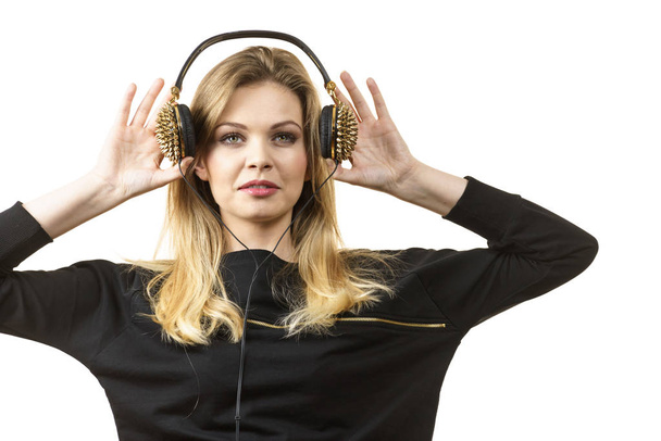 Teenager young grunge woman wearing black and listening to music on headphones with spikes - 写真・画像
