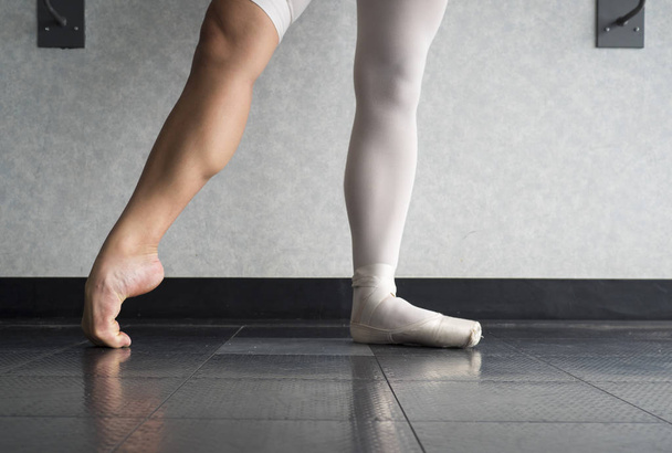 La trabajadora bailarina de ballet disciplinada calentándose en sus zapatos puntiagudos y pies desnudos, mostrando el detrás de las escenas de una bailarina
 - Foto, Imagen